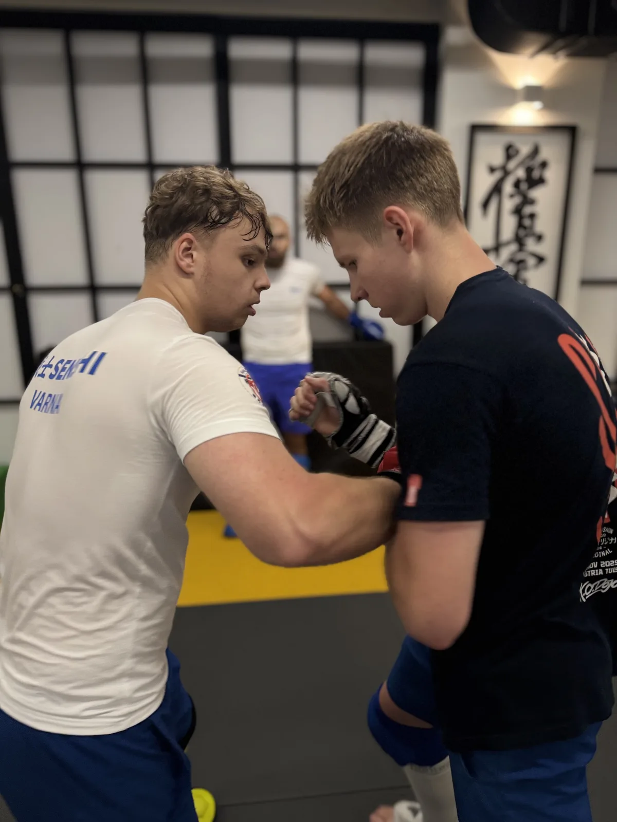 Archive photo of two students checking hand wraps before sparring